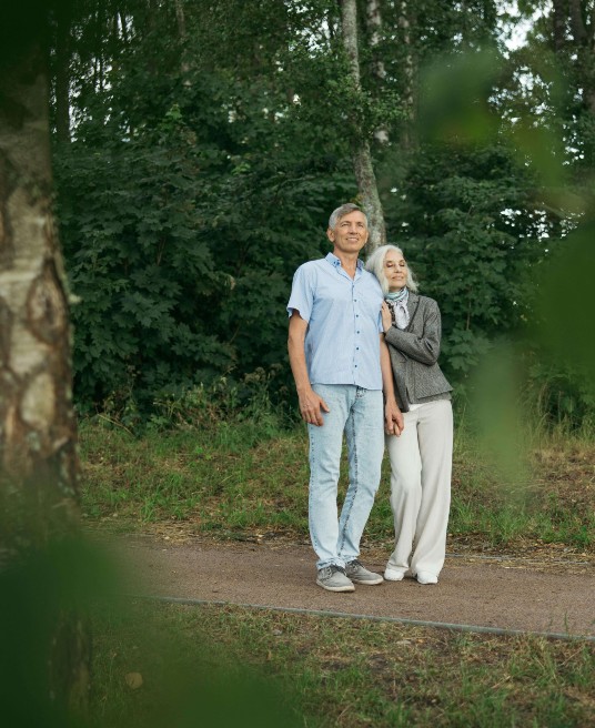 An elderly couple stands close, leaning on each other in the forest. Therapy for relationship issues can help couples build resilience and closeness. A relationship therapist in Delray Beach, FL, supports healthier patterns for long-term love.