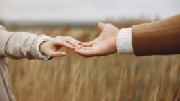 Two hands gently reach for each other in a wheat field, symbolizing trust and reconnection. Marriage expectations can shift over time and cause strain. Relationship therapy in Delray Beach, FL supports couples in redefining their future together.