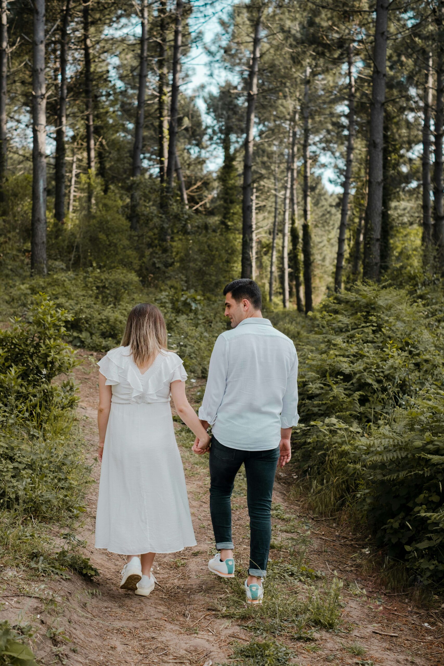 A young couple walks hand in hand down a wooded path. Therapy for relationship issues can encourage couples to grow closer and navigate challenges. A relationship therapist in Delray Beach, FL, offers support for a lasting connection.