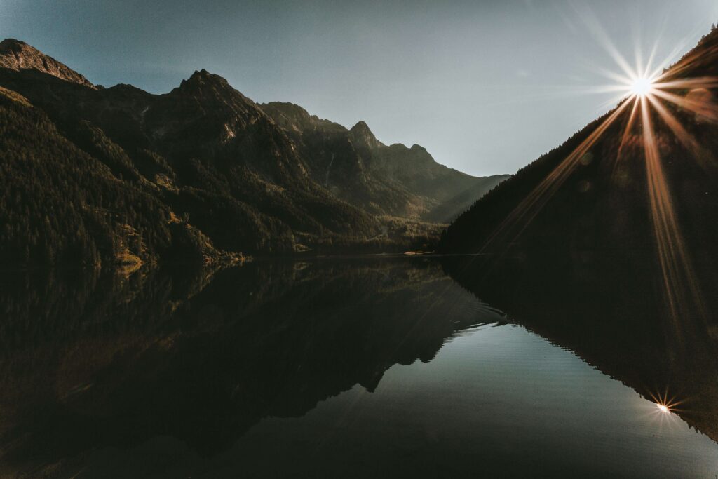Sunlight breaks over a mountain ridge, reflecting on still water. Anxiety in romantic relationships can overshadow joy, but hope is possible. A relationship therapist in Delray Beach, FL, can guide you toward clarity, peace, and a stronger bond.