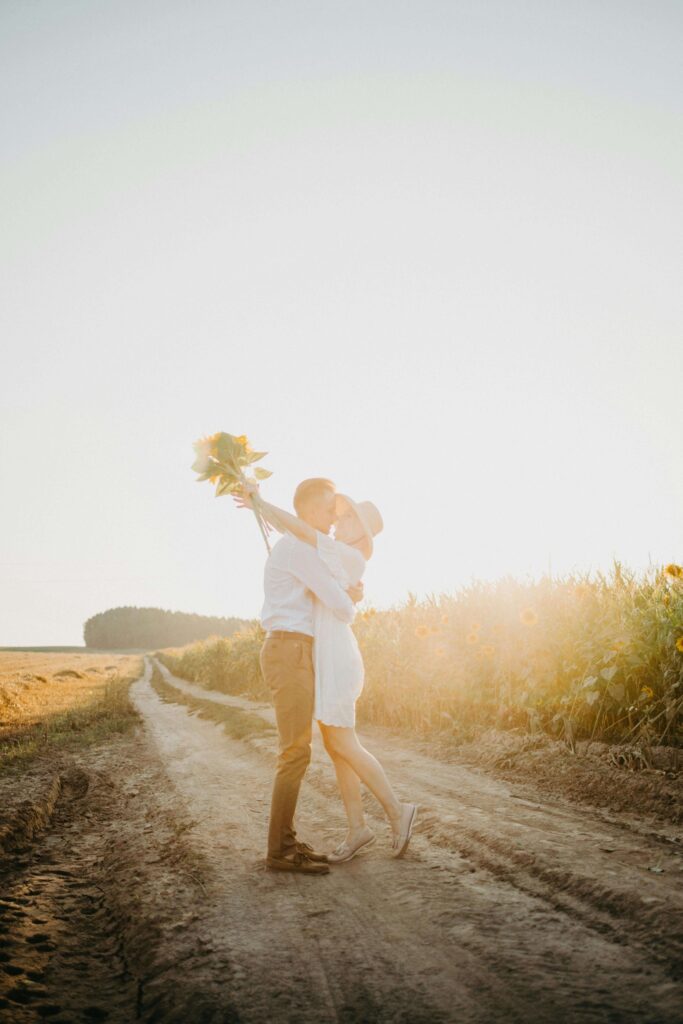 A couple embraces under the evening sun in a sunflower field, expressing love and hope. Marriage expectations can create misunderstandings when unspoken. Relationship therapy in Delray Beach, FL helps partners communicate and strengthen their bond.