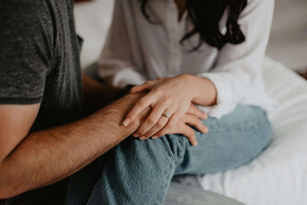 A couple gently holds hands while sitting together, showing comfort and care. Exploring marriage expectations during premarital relationship counseling can deepen connection. Relationship therapy in Delray Beach, FL, support a couple's growth.