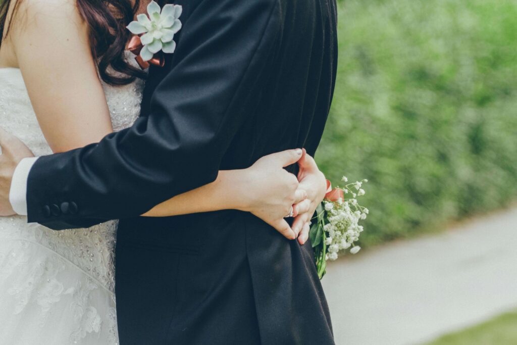 A bride and groom embrace outdoors after their wedding ceremony. Clear relationship expectations are vital before marriage. Premarital relationship counseling in Delray Beach, FL, encourages open communication for healthy unions.