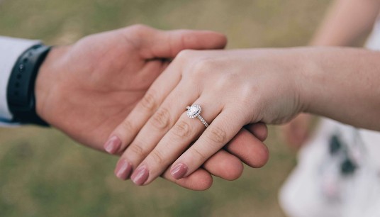 Two hands gently touch, showing an engagement ring. Couples discussing marriage expectations can strengthen emotional understanding. A premarital relationship therapist in Delray Beach, FL, helps partners prepare for lasting commitment.