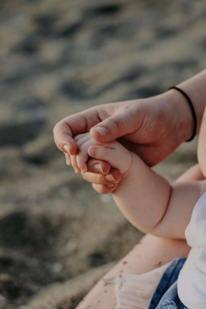 A mother's hand holds her child's hand. Does being a parent intensify anxiety? An anxiety therapist in Delray Beach, FL, works with parents to understand triggers and develop calming strategies that protect the parent-child relationship. 