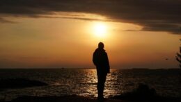 Silhouette of a man thinking while facing a dramatic sunset over a calm ocean. Overthinking can leave you feeling isolated and stuck inside your own mind. An anxiety therapist in Delray Beach, FL, can help you find peace and clarity.