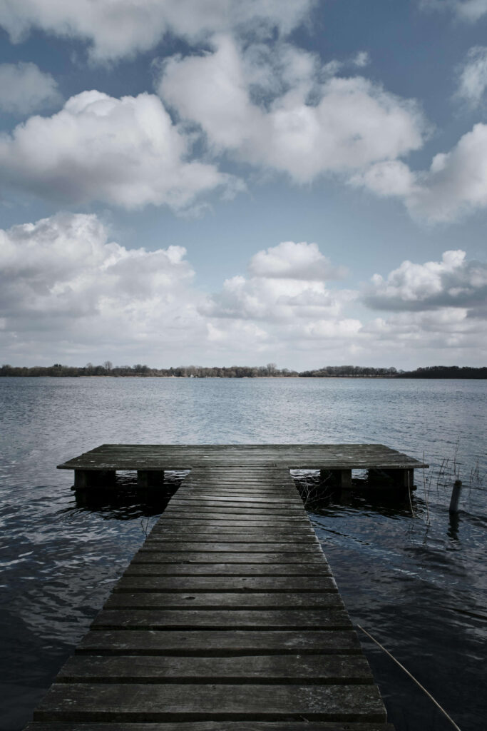 A wooden dock extends over a calm lake. Is difficulty with eye contact creating distance between you and others in your social and professional life? An anxiety therapist in Delray Beach, FL, can help you explore what's driving that disconnect.