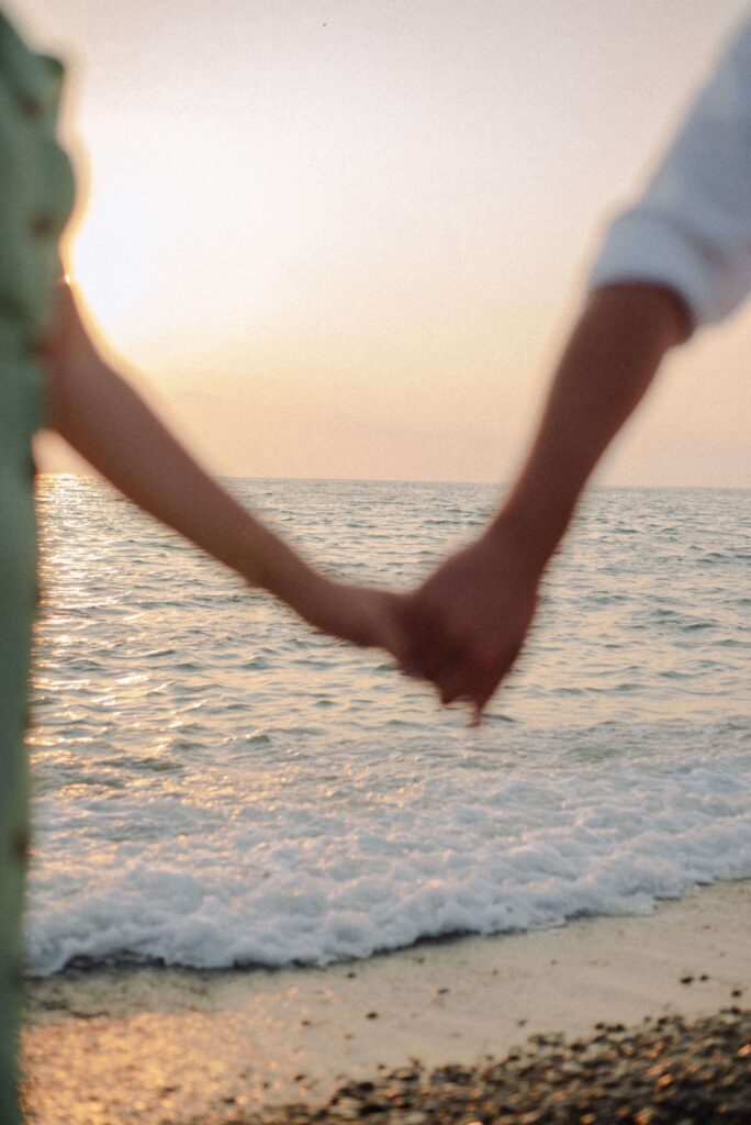 Holding hands | anxiety therapist in delray beach, fl | chronic anxiety | anxiety therapy | Delray Beach, Florida | Highland Beach | Palm Beach County | Boynton Beach Two people hold hands while standing along the shoreline at sunset. How can chronic anxiety affect emotional connections and relationships? Anxiety therapy in Delray Beach, FL, can help you understand persistent worry and develop healthier coping strategies.